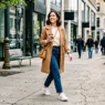 Woman in perfectly coordinated casual outfit walking confidently on city sidewalk with natural styling