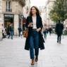 Woman walking on city sidewalk in classy casual outfit with natural lighting and blurred urban background