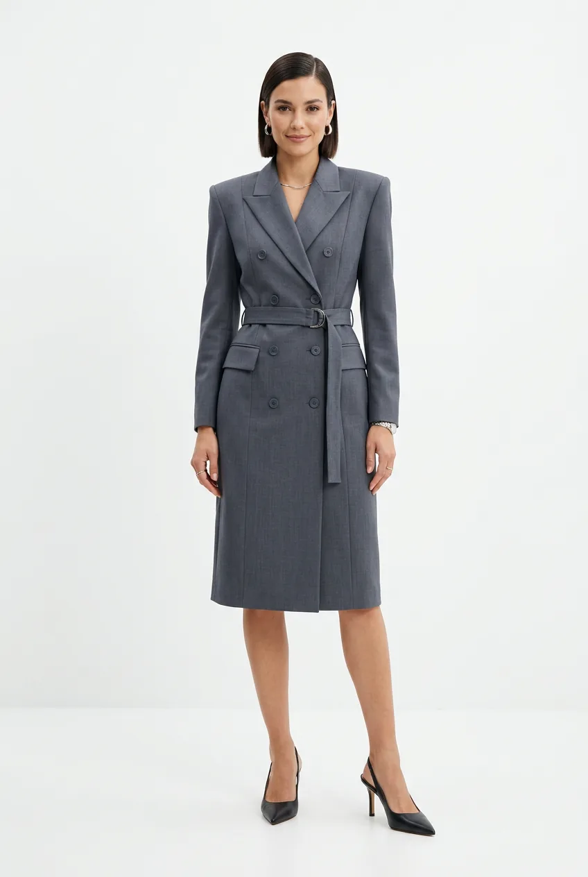 Woman in structured slate grey suiting-weight blazer dress with strong shoulders and below-knee hemline