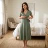 Woman in sage ponte midi wrap dress smoothing front of skirt in softly lit bedroom with weather app visible on dresser