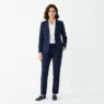 Woman in perfectly tailored navy blazer and matching trousers with white blouse, full-length studio portrait
