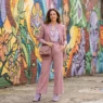 Woman in dusty rose and lavender Y2K styled outfit posed in front of a vibrant painted street mural in soft daylight